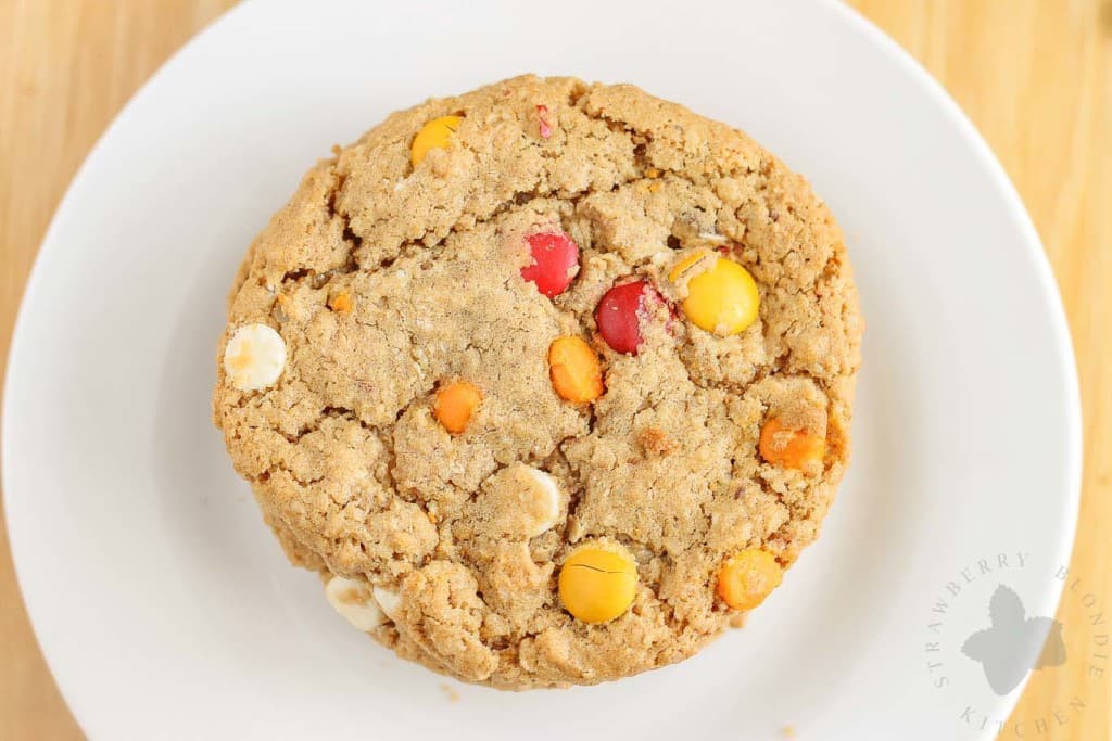 Monster cookies taken up a notch with the flavors of Autumn are both delicious and festive. Peanut butter mixed with pumpkin pie spice, white chocolate and pumpkin spice flavored chips and fall colored m & m's make these autumn monster cookies the perfect treat to serve all season long!