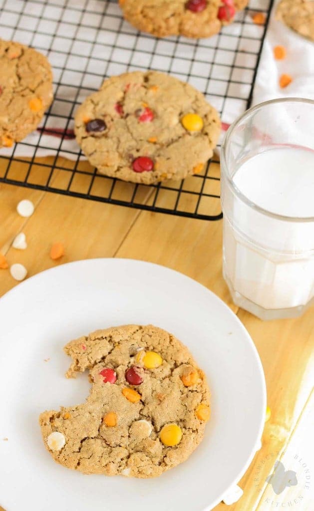 Monster cookies taken up a notch with the flavors of Autumn are both delicious and festive. Peanut butter mixed with pumpkin pie spice, white chocolate and pumpkin spice flavored chips and fall colored m & m's make these autumn monster cookies the perfect treat to serve all season long! | Strawberry Blondie Kitchen