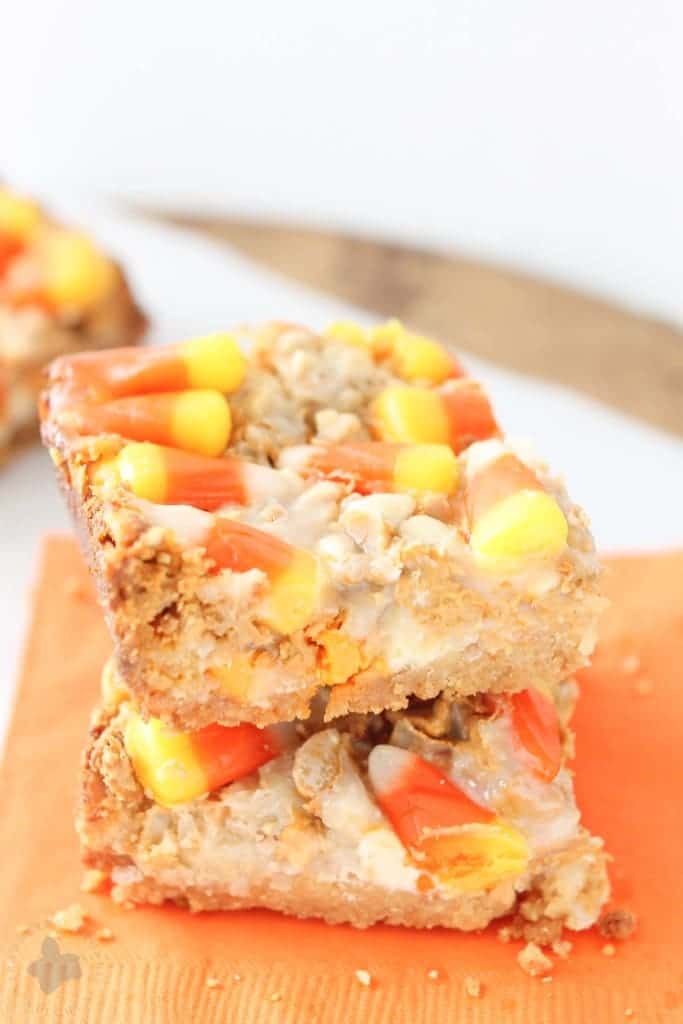 Candy Corn Magic bars are a real Halloween treat and will be a hit at your next party! They feature 7 layers of oreo crust, coconut, peanuts, white chocolate chips, butterscotch chips, sweetened condensed milk and candy corn pieces. With a combination like that, how could you go wrong? | Strawberry Blondie Kitchen