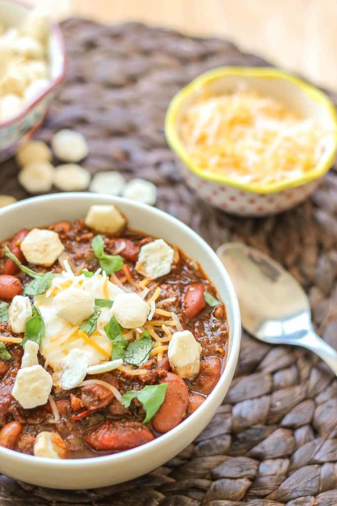 Chorizo Chili with Jalapeño Cornbread Waffles is perfect for game day, a chilly fall night or neighborhood potluck. This beefy flavored packed chili gets a slight kick from the spicy chorizo sausage. Served on top of cornbread waffles, dolloped with cheese and cilantro, and you've got yourself a well rounded meal! | Strawberry Blondie Kitchen