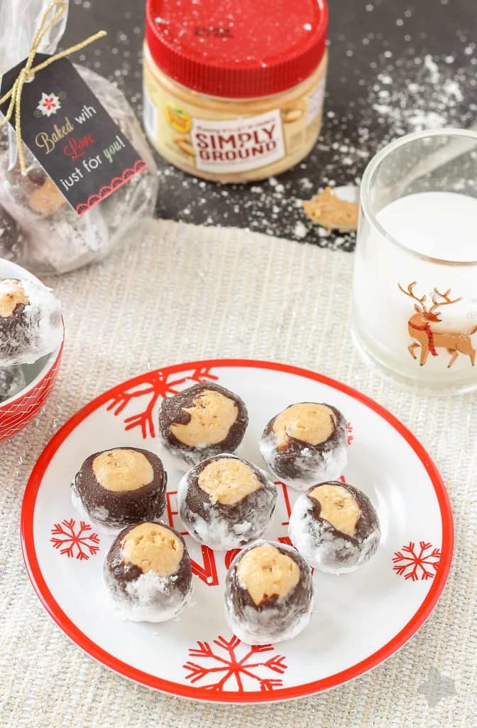 Creamy with a little bit of crunch, Peter Pan® Simply Ground Peanut Butter works beautifully in these Puppy Chow Truffles. Peanut butter balls dipped in chocolate and rolled in powdered sugar are the perfect treat to pass out to all your friends, family and coworkers this holiday season. Bonus-free printable holiday cookie gift tag! No excuses! | Strawberry Blondie Kitchen