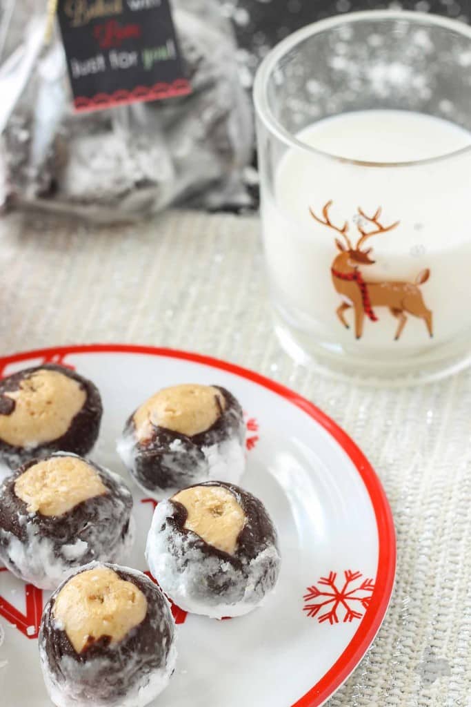 Creamy with a little bit of crunch, Peter Pan® Simply Ground Peanut Butter works beautifully in these Puppy Chow Truffles. Peanut butter balls dipped in chocolate and rolled in powdered sugar are the perfect treat to pass out to all your friends, family and coworkers this holiday season. Bonus-free printable holiday cookie gift tag! No excuses! | Strawberry Blondie Kitchen