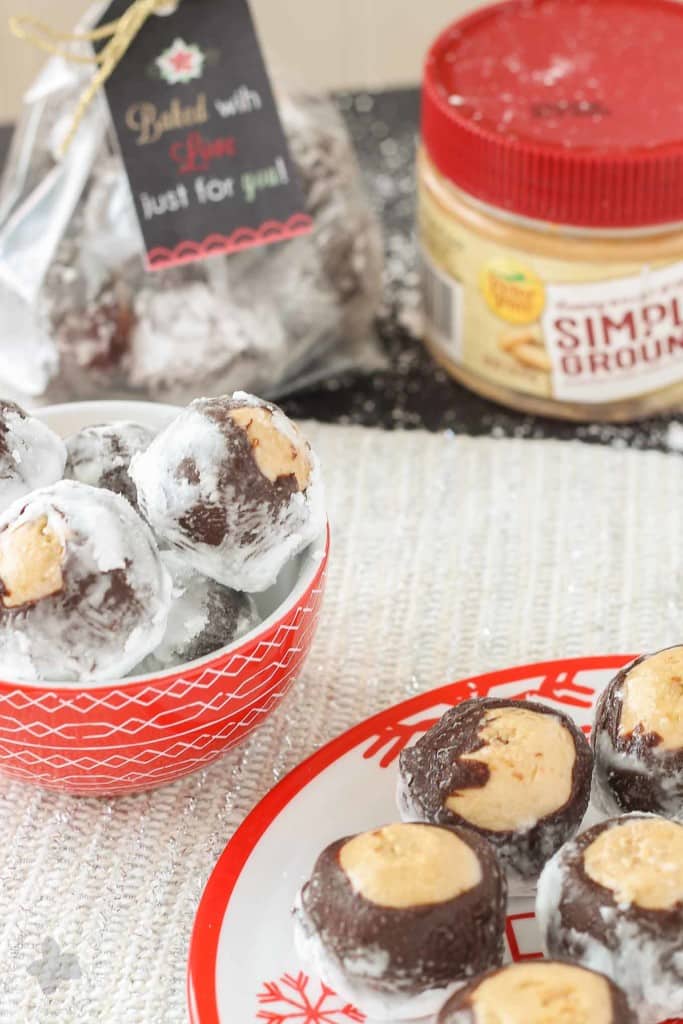 Creamy with a little bit of crunch, Peter Pan® Simply Ground Peanut Butter works beautifully in these Puppy Chow Truffles. Peanut butter balls dipped in chocolate and rolled in powdered sugar are the perfect treat to pass out to all your friends, family and coworkers this holiday season. Bonus-free printable holiday cookie gift tag! No excuses! | Strawberry Blondie Kitchen