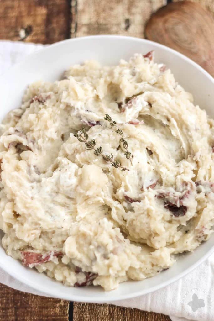 Free up space in your oven this holiday season with these Slow Cooker Goat Cheese Mashed Potatoes. They're tangy and full of garlic flavor from the herb goat cheese, fluffy and irresistibly delicious. They're sure to have your guests going back for seconds! | Strawberry Blondie Kitchen