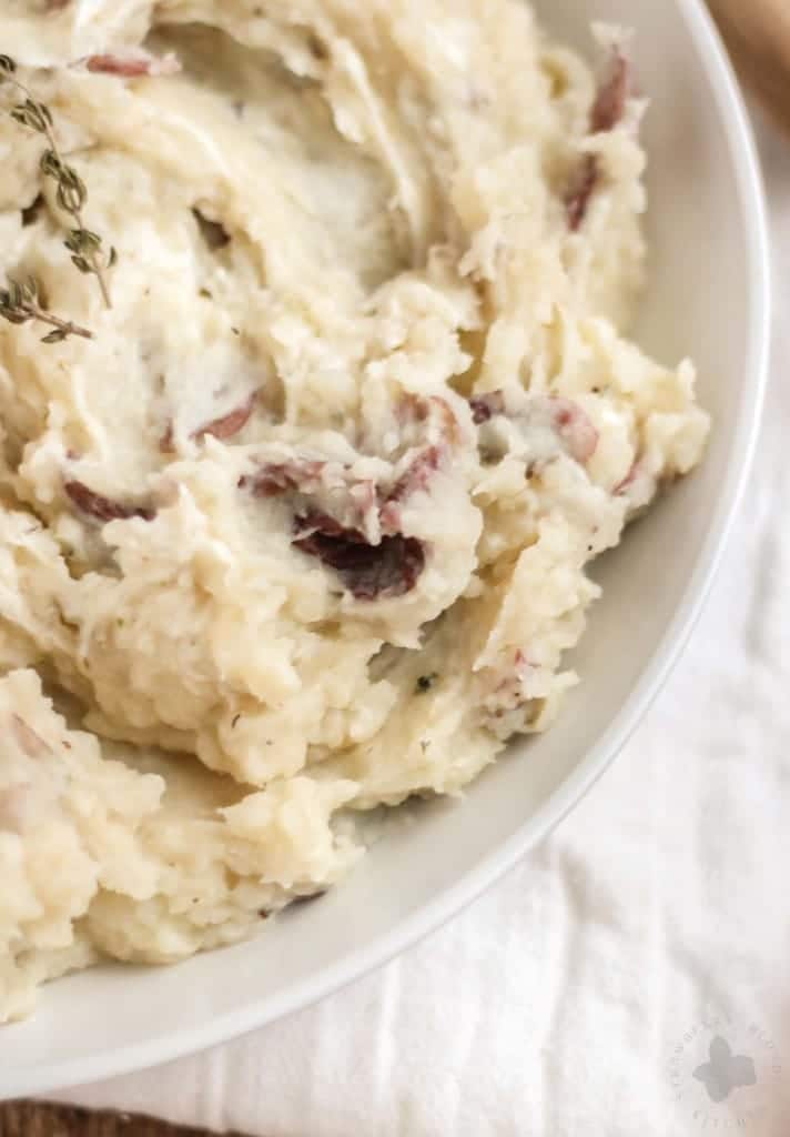 Free up space in your oven this holiday season with these Slow Cooker Goat Cheese Mashed Potatoes. They're tangy and full of garlic flavor from the herb goat cheese, fluffy and irresistibly delicious. They're sure to have your guests going back for seconds! | Strawberry Blondie Kitchen