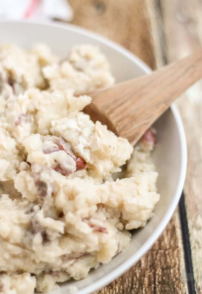 Free up space in your oven this holiday season with these Slow Cooker Goat Cheese Mashed Potatoes. They're tangy and full of garlic flavor from the herb goat cheese, fluffy and irresistibly delicious. They're sure to have your guests going back for seconds! | Strawberry Blondie Kitchen