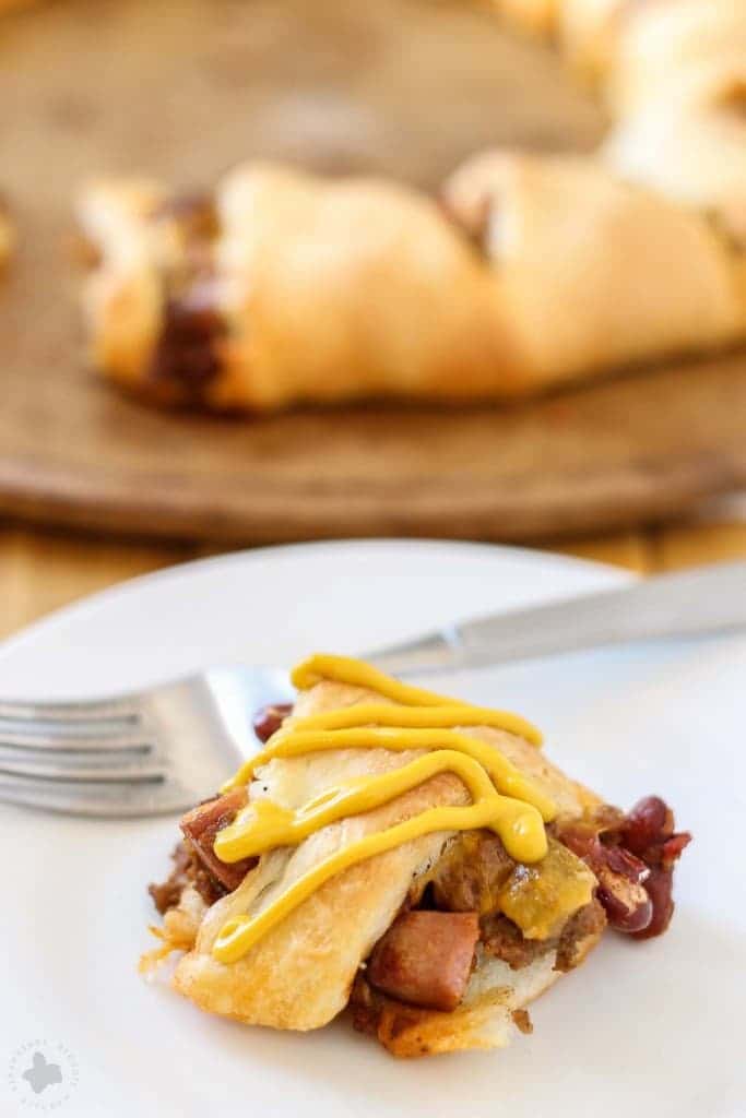 The flavors of an American classic, the chili cheese dog, have been rolled up into a crescent ring to bring you the ultimate game time food. You'll please even the pickiest of eaters with this Chili Cheese Dog Crescent Ring during dinnertime or any occasion. | Strawberry Blondie Kitchen