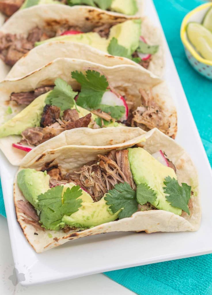 Tender, spicy, moist and juicy these Slow Cooker Spicy Pork Carnitas are perfect for the BIG GAME! Place on top of a tortilla with fresh ingredients, piled high on nachos or sandwiched between bread, no matter how you serve them, you've got a crowd pleaser perfect for game day, dinner or a fiesta! | Strawberry Blondie Kitchen