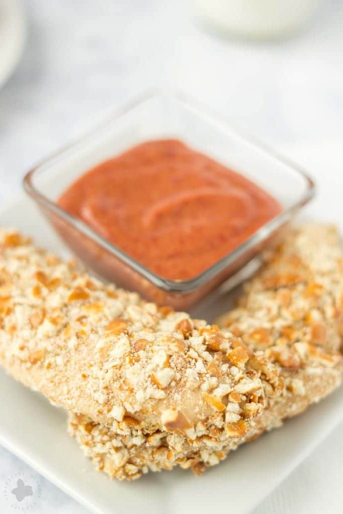 Kids starving after school and you’re tired of feeding them the same ole snack? Try these Pretzel Crusted Chicken Tenders. Chicken Tender strips are coated in Goldfish® Pretzel crackers, baked in the oven and served with a delicious Blackberry honey mustard sauce dipping sauce your kids will love! | Strawberry Blondie Kitchen