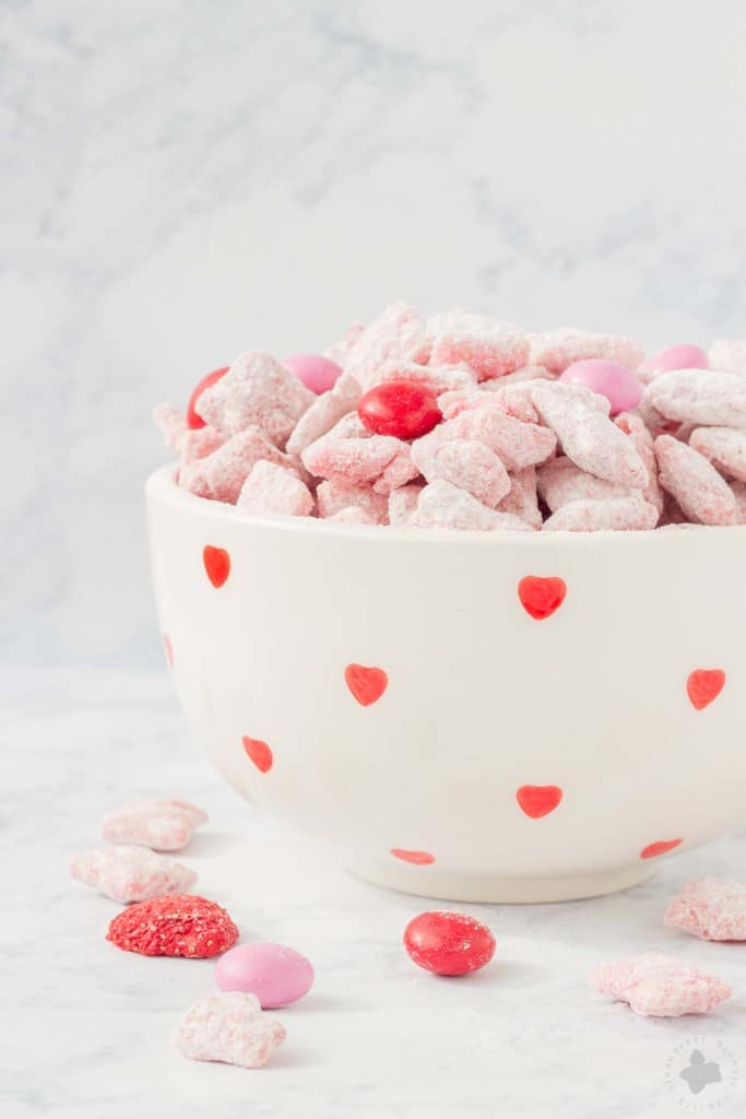 Strawberry Puppy Chow is deliciously sweet, crunchy and highly addictive. A tasty and sweet snack your sweetheart is sure to love! | Strawberry Blondie Kitchen