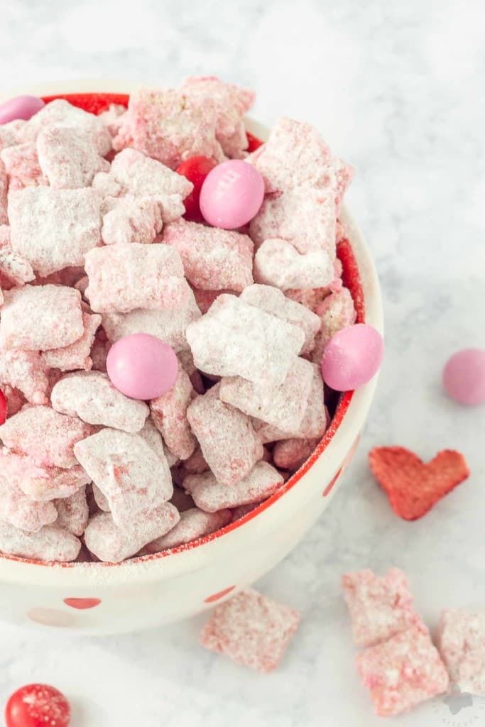 Strawberry Puppy Chow is deliciously sweet, crunchy and highly addictive. A tasty and sweet snack your sweetheart is sure to love! | Strawberry Blondie Kitchen