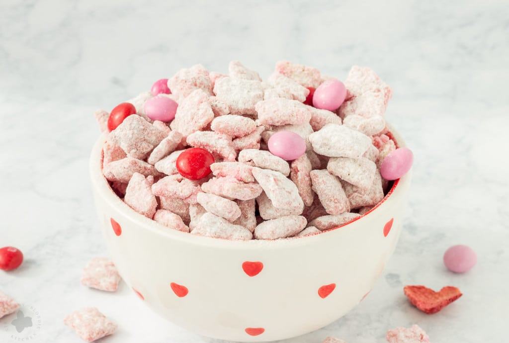 Strawberry Puppy Chow is deliciously sweet, crunchy and highly addictive. A tasty and sweet snack your sweetheart is sure to love! | Strawberry Blondie Kitchen