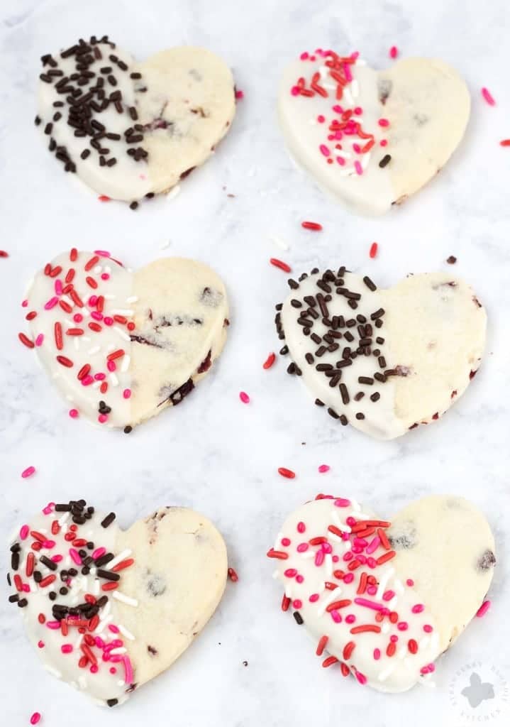 Surprise and delight your Valentine with these White Chocolate Cranberry Shortbread Heart Cookies. Nothing says I love you more than fresh home baked cookies shaped like hearts, dipped in white chocolate and covered in sprinkles!
