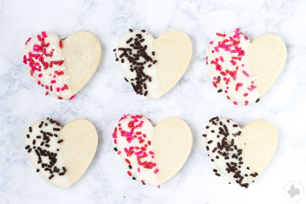 Surprise and delight your Valentine with these White Chocolate Cranberry Shortbread Heart Cookies. Nothing says I love you more than fresh home baked cookies shaped like hearts, dipped in white chocolate and covered in sprinkles!