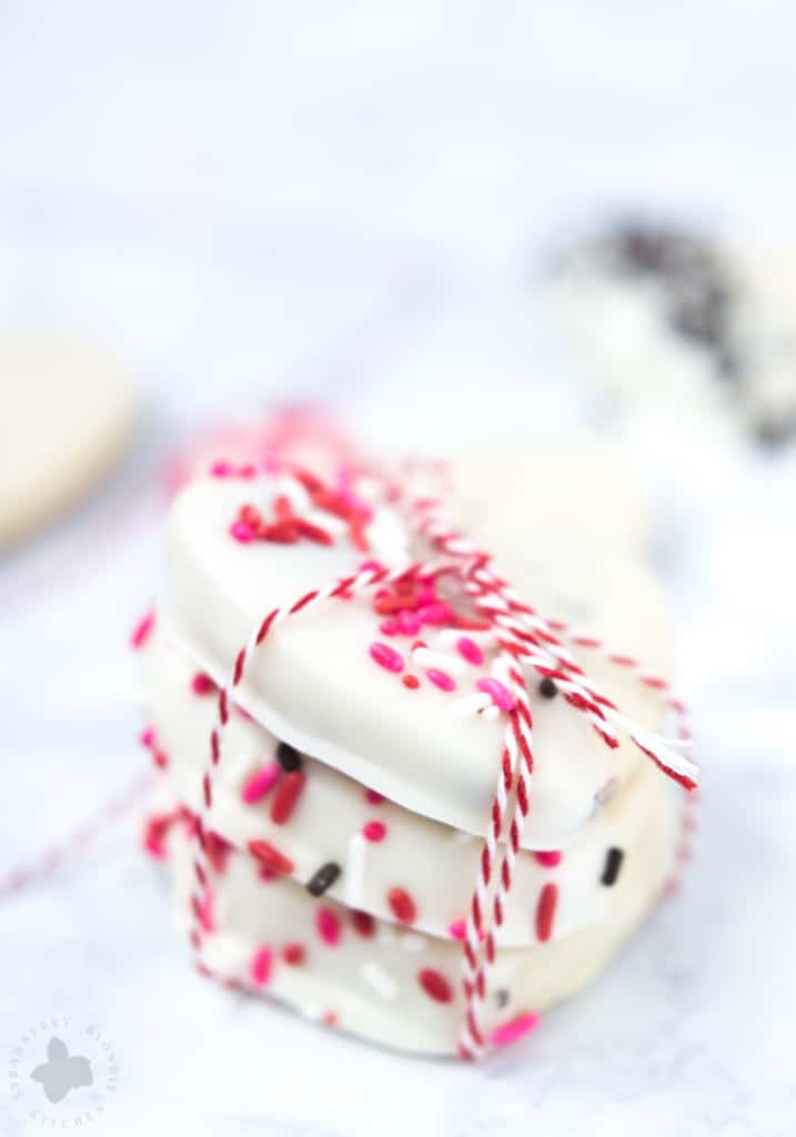 Surprise and delight your Valentine with these White Chocolate Cranberry Shortbread Heart Cookies. Nothing says I love you more than fresh home baked cookies shaped like hearts, dipped in white chocolate and covered in sprinkles!