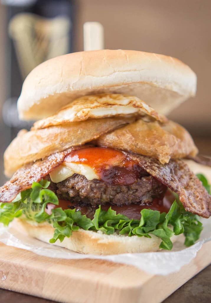 An All American beef patty with Guinness Battered Onion rings, Jameson BBQ sauce and Candied Baileys Bacon, this Irish Car Bomb Burger is literally a flavor bomb! | Strawberry Blondie Kitchen