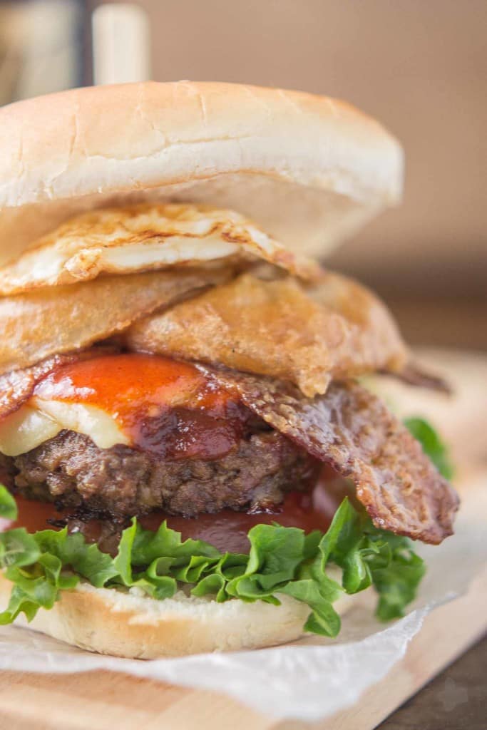 An All American beef patty with Guinness Battered Onion rings, Jameson BBQ sauce and Candied Baileys Bacon, this Irish Car Bomb Burger is literally a flavor bomb! | Strawberry Blondie Kitchen