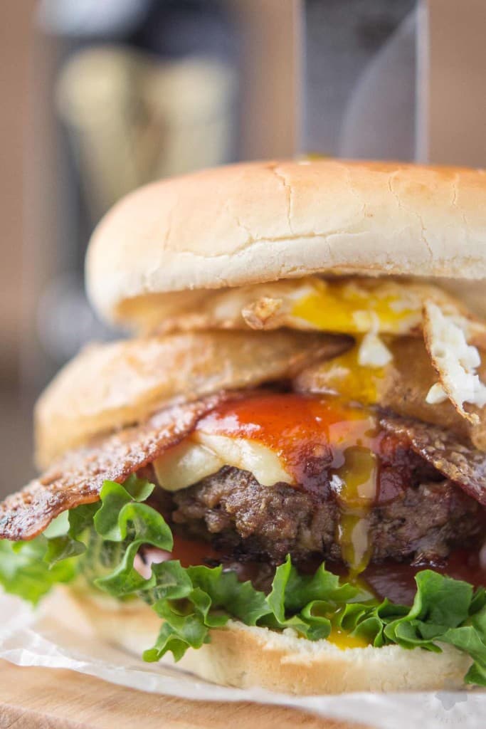 An All American beef patty with Guinness Battered Onion rings, Jameson BBQ sauce and Candied Baileys Bacon, this Irish Car Bomb Burger is literally a flavor bomb! | Strawberry Blondie Kitchen