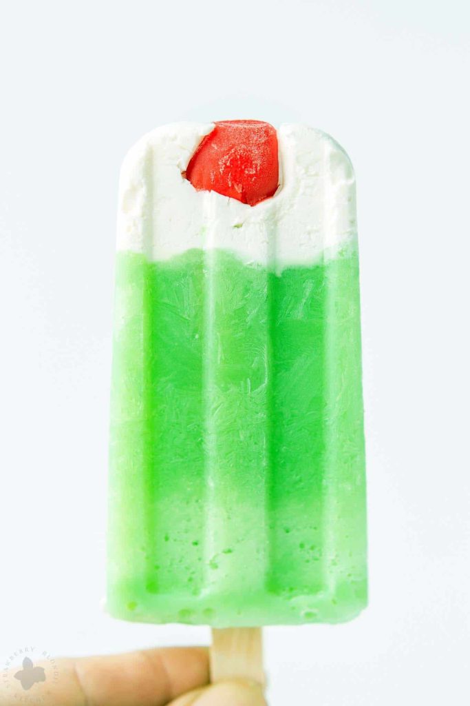 The classic Shamrock Shake you know and love turned Popsicle. Cool, creamy mint flavored frozen yogurt popsicles complete with whipped cream and a cherry on top! | Strawberry Blondie Kitchen