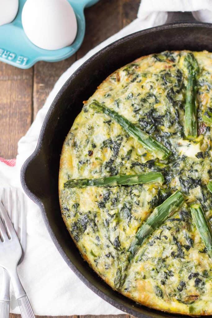 Bursting with springtime flavors, this Asparagus and Spinach Frittata is the perfect dish to wake up to in the morning. Fresh asparagus, spinach and tangy goat cheese pair nicely to give you a healthy balanced breakfast, snack or meal any time | Strawberry Blondie Kitchen