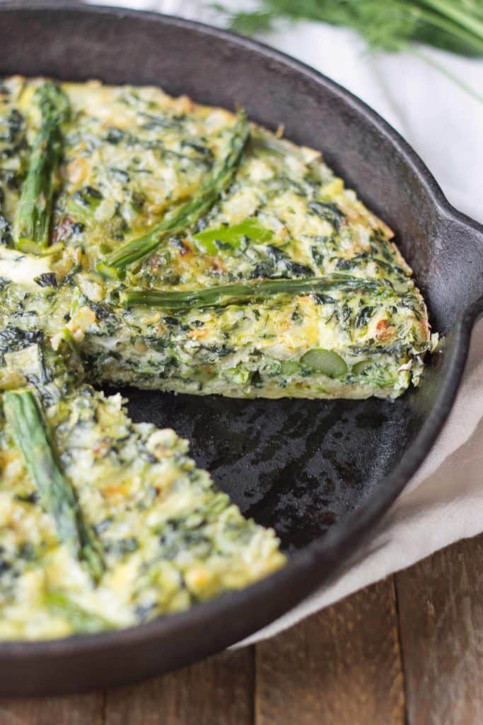 Bursting with springtime flavors, this Asparagus and Spinach Frittata is the perfect dish to wake up to in the morning. Fresh asparagus, spinach and tangy goat cheese pair nicely to give you a healthy balanced breakfast, snack or meal any time | Strawberry Blondie Kitchen