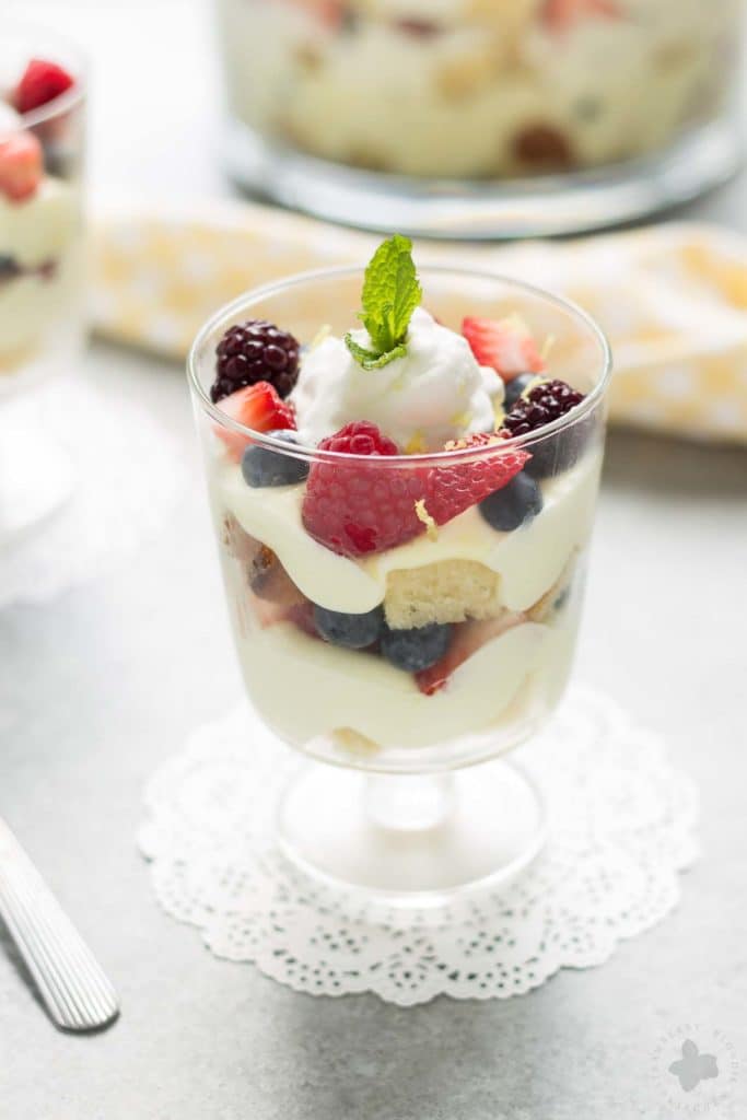 Celebrate the bountiful berries of the season with this Lemon Berry Trifle. Strawberries, blueberries, raspberries and blackberries are layered between tart lemon pudding, whipped cream and studded with delicious pound cake. The perfect summer dessert for all your backyard parties! | Strawberry Blondie Kitchen