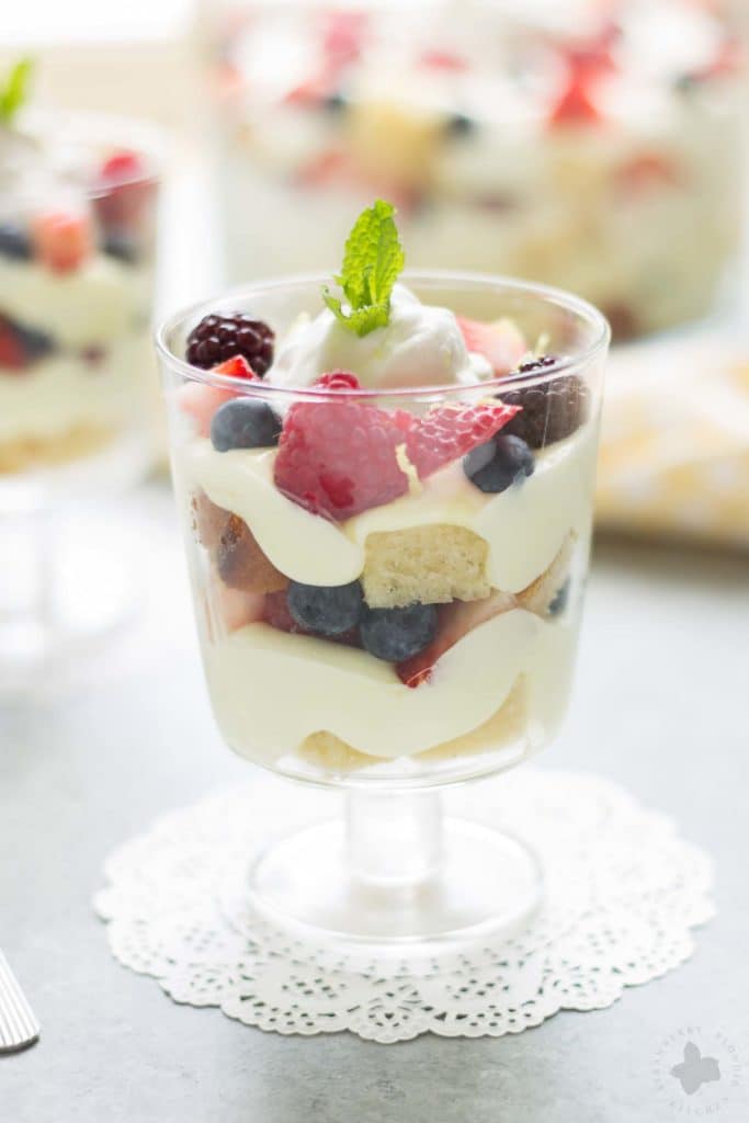 Celebrate the bountiful berries of the season with this Lemon Berry Trifle. Strawberries, blueberries, raspberries and blackberries are layered between tart lemon pudding, whipped cream and studded with delicious pound cake. The perfect summer dessert for all your backyard parties! | Strawberry Blondie Kitchen