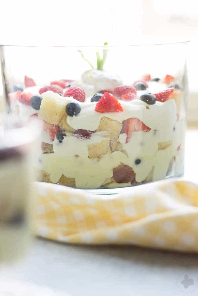 Celebrate the bountiful berries of the season with this Lemon Berry Trifle. Strawberries, blueberries, raspberries and blackberries are layered between tart lemon pudding, whipped cream and studded with delicious pound cake. The perfect summer dessert for all your backyard parties! | Strawberry Blondie Kitchen