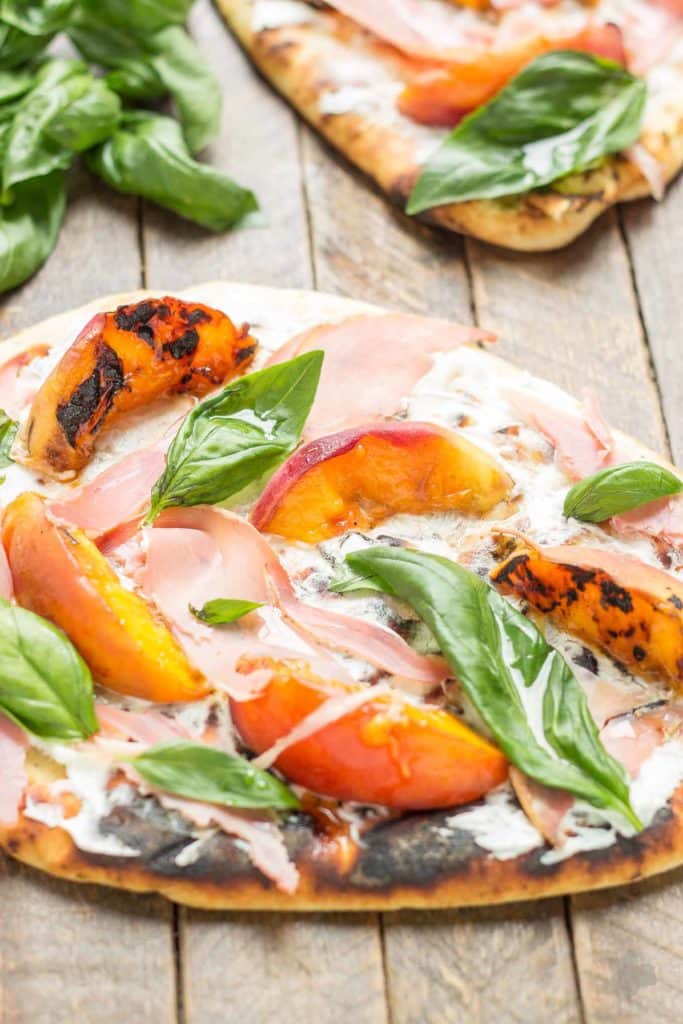 Tender and sweet peaches are a match made in Heaven with salty prosciutto, tangy, creamy goat cheese all piled high on garlic naan bread. This Grilled Peach, Prosciutto and Goat Cheese Pizza will have your taste buds singing the sweet and savory tunes of summer | Strawberry Blondie Kitchen