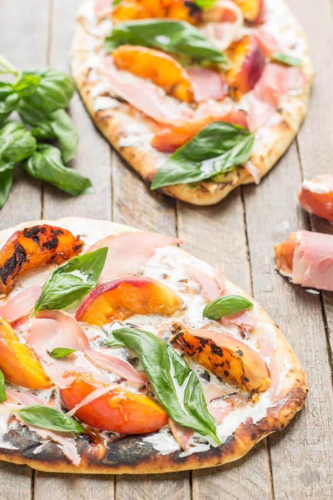 Tender and sweet peaches are a match made in Heaven with salty prosciutto, tangy, creamy goat cheese all piled high on garlic naan bread. This Grilled Peach, Prosciutto and Goat Cheese Pizza will have your taste buds singing the sweet and savory tunes of summer | Strawberry Blondie Kitchen