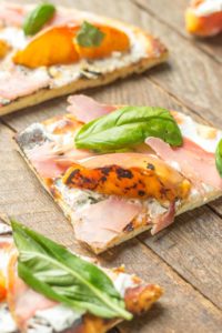 Tender and sweet peaches are a match made in Heaven with salty prosciutto, tangy, creamy goat cheese all piled high on garlic naan bread. This Grilled Peach, Prosciutto and Goat Cheese Pizza will have your taste buds singing the sweet and savory tunes of summer | Strawberry Blondie Kitchen