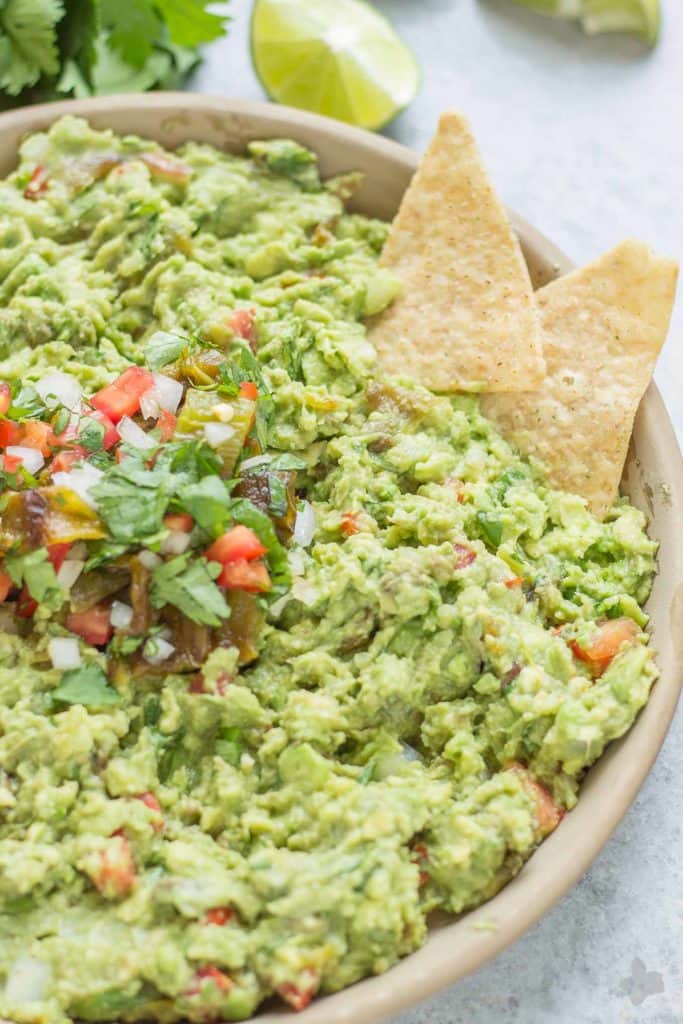 Add a little heat and smokiness to your guacamole with fire roasted hatch chiles. Only in season for a short time, so get your hands on some of these babies and make this delicious, crowd pleasing Hatch Chile Guacamole. | Strawberry Blondie Kitchen