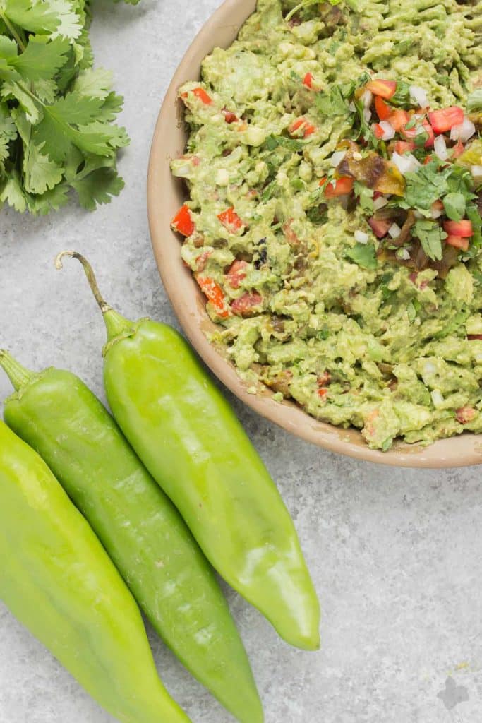 Add a little heat and smokiness to your guacamole with fire roasted hatch chiles. Only in season for a short time, so get your hands on some of these babies and make this delicious, crowd pleasing Hatch Chile Guacamole. | Strawberry Blondie Kitchen