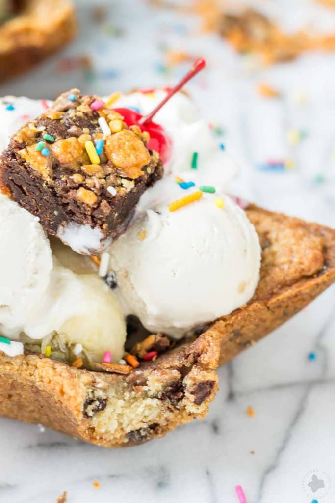 Freshly baked chocolate chip cookies are molded into bowls and piled high with all your favorite ice cream sundae favorites. Now you can have your ice cream and eat the bowl too! The Ultimate Ice Cream Sundae Bowl are an ice cream lovers dream. | Strawberry Blondie Kitchen