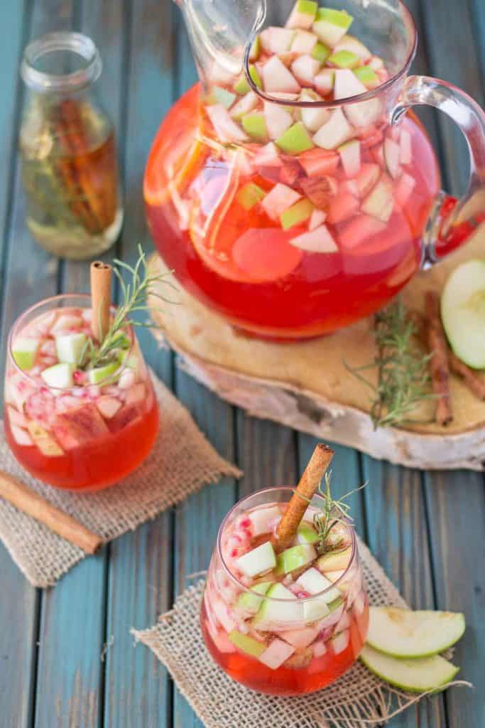 A delicious blend of cranberries, apples, cinnamon, rosemary and seasonal fruits make this Cranberry Apple Rosemary Sangria the go to cocktail of Autumn. | Strawberry Blondie Kitchen