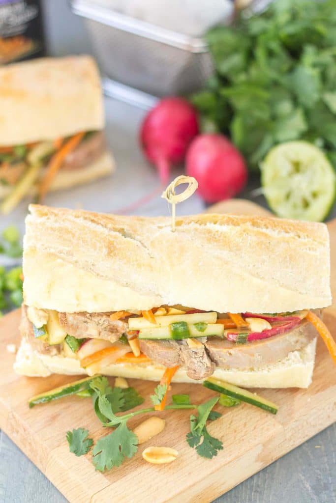 These Banh Mi Sandwiches are packed with bold Asian flavors. Pork is marinated in House of Tsang Szechuan SpicyTM Sauce and their Bangkok Peanut SauceTM dresses the vegetable coleslaw, which is piled high on top the pork. A few peanuts are added for crunch and you’ve got yourself the perfect Banh Mi Sandwich. | Strawberry Blondie Kitchen