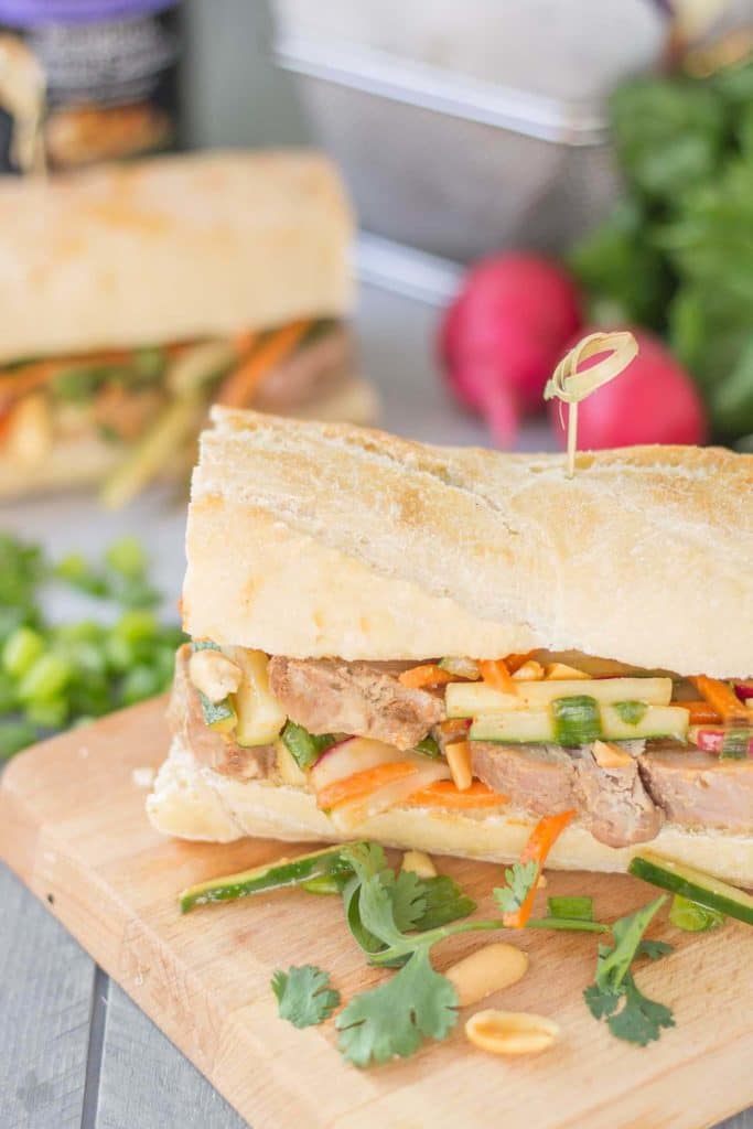 These Banh Mi Sandwiches are packed with bold Asian flavors. Pork is marinated in House of Tsang Szechuan SpicyTM Sauce and their Bangkok Peanut SauceTM dresses the vegetable coleslaw, which is piled high on top the pork. A few peanuts are added for crunch and you’ve got yourself the perfect Banh Mi Sandwich. | Strawberry Blondie Kitchen
