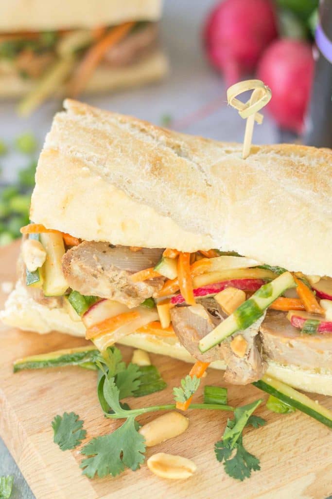 These Banh Mi Sandwiches are packed with bold Asian flavors. Pork is marinated in House of Tsang Szechuan SpicyTM Sauce and their Bangkok Peanut SauceTM dresses the vegetable coleslaw, which is piled high on top the pork. A few peanuts are added for crunch and you’ve got yourself the perfect Banh Mi Sandwich. | Strawberry Blondie Kitchen