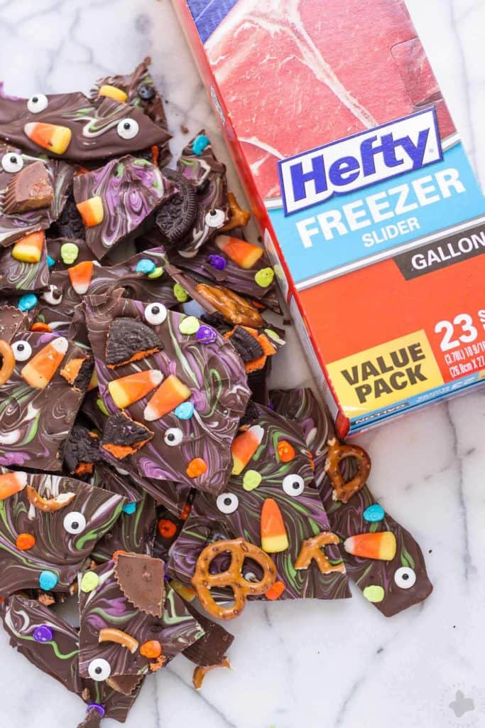 Halloween Candy Bark is a fun and spooky way to bring the deliciousness of Halloween candy into a colorful, no bake bark your whole family can customize. Use Hefty® Slider Bags and cleanup is a breeze! | Strawberry Blondie Kitchen