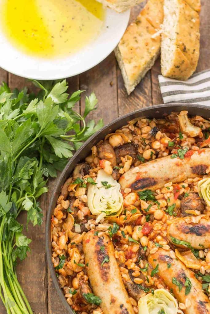 One Pan Tuscan Italian Sausages is a delicious savory dish packed with the big flavors featuring Bertolli pasta sauce cannellini beans, mushrooms, artichokes and nutty farro. Bring the flavors of Tuscany right into your kitchen! | Strawberry Blondie Kitchen