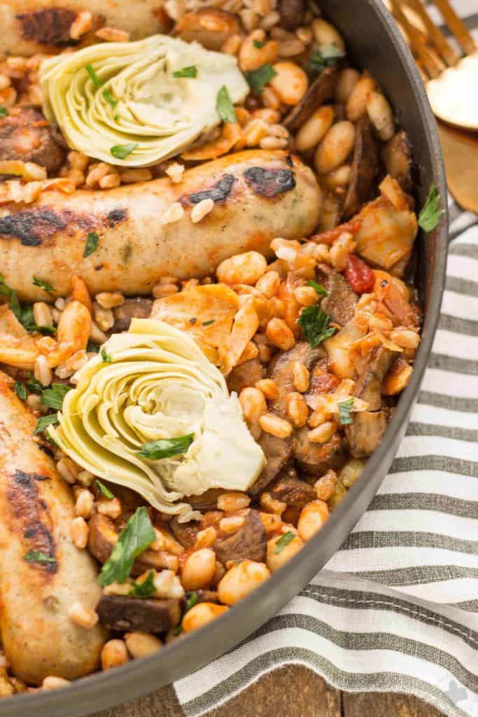 One Pan Tuscan Italian Sausages is a delicious savory dish packed with the big flavors featuring Bertolli pasta sauce cannellini beans, mushrooms, artichokes and nutty farro. Bring the flavors of Tuscany right into your kitchen! | Strawberry Blondie Kitchen