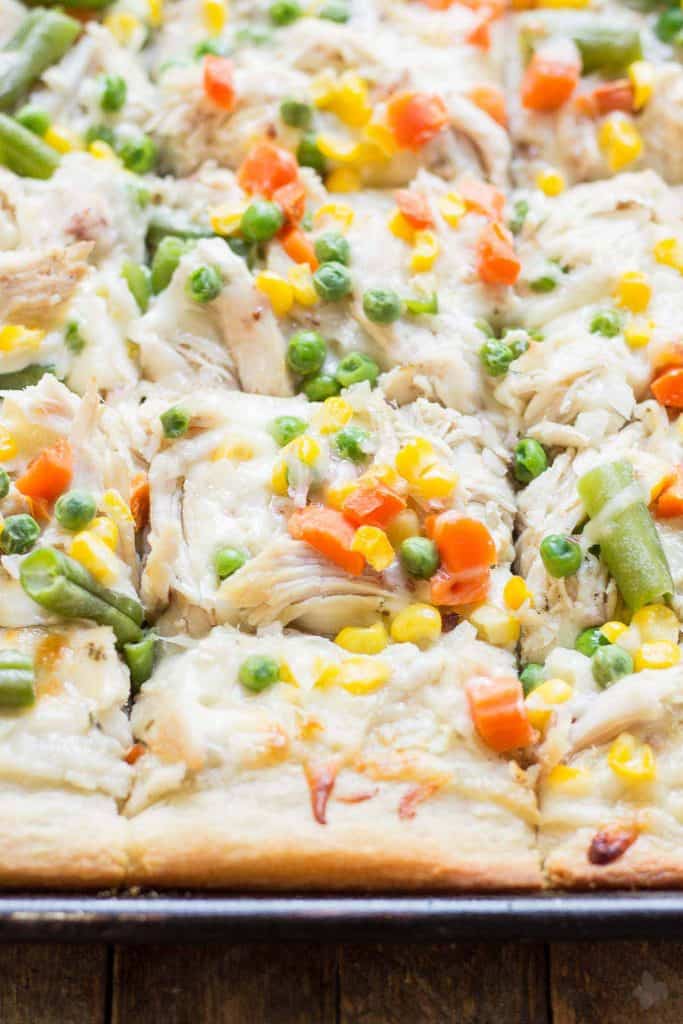 No one will be able to say no to Leftover Turkey Pot Pie Slab Pizza. Filled with extra cheese, vegetables and turkey, this pizza tastes exactly like a delicious pot pie! Perfect for game day, feeding a crowd and using up Thanksgiving leftovers! | Strawberry Blondie Kitchen