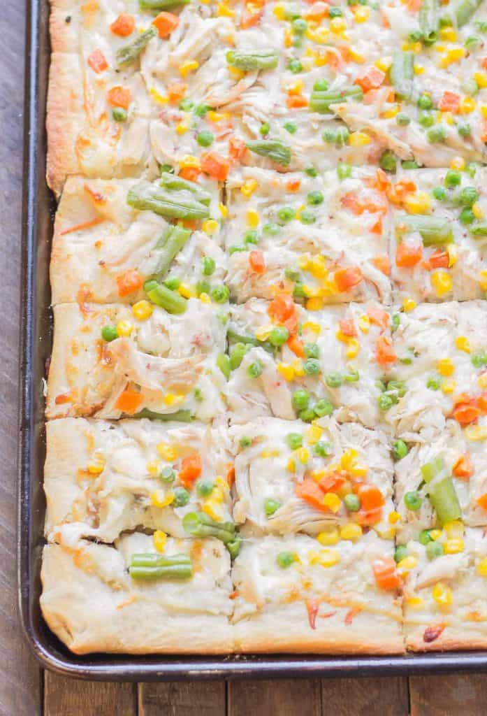 No one will be able to say no to Leftover Turkey Pot Pie Slab Pizza. Filled with extra cheese, vegetables and turkey, this pizza tastes exactly like a delicious pot pie! Perfect for game day, feeding a crowd and using up Thanksgiving leftovers! | Strawberry Blondie Kitchen