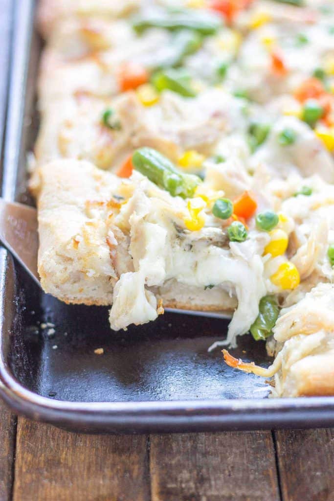 No one will be able to say no to Leftover Turkey Pot Pie Slab Pizza. Filled with extra cheese, vegetables and turkey, this pizza tastes exactly like a delicious pot pie! Perfect for game day, feeding a crowd and using up Thanksgiving leftovers! | Strawberry Blondie Kitchen