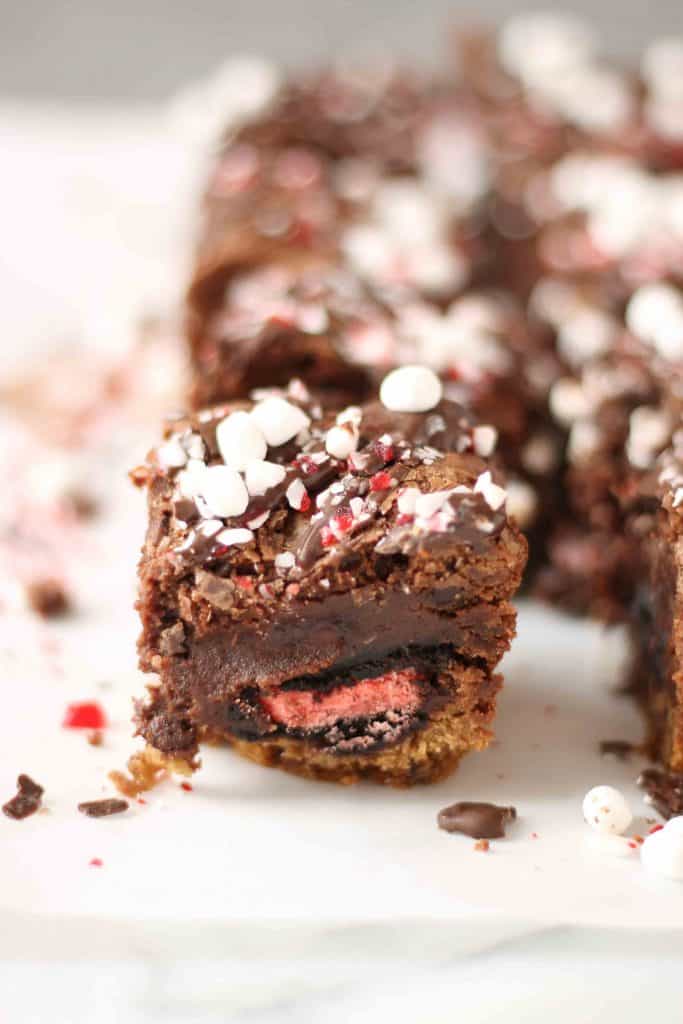 These Peppermint Hot Chocolate Brookies feature a layer of chocolate chip cookies, peppermint sandwich cookies, a layer of brownies and then topped with dark chocolate, crushed peppermint and mini marshmallows. | Strawberry Blondie Kitchen