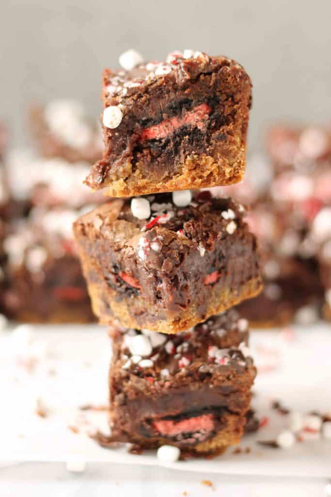 These Peppermint Hot Chocolate Brookies feature a layer of chocolate chip cookies, peppermint sandwich cookies, a layer of brownies and then topped with dark chocolate, crushed peppermint and mini marshmallows. | Strawberry Blondie Kitchen