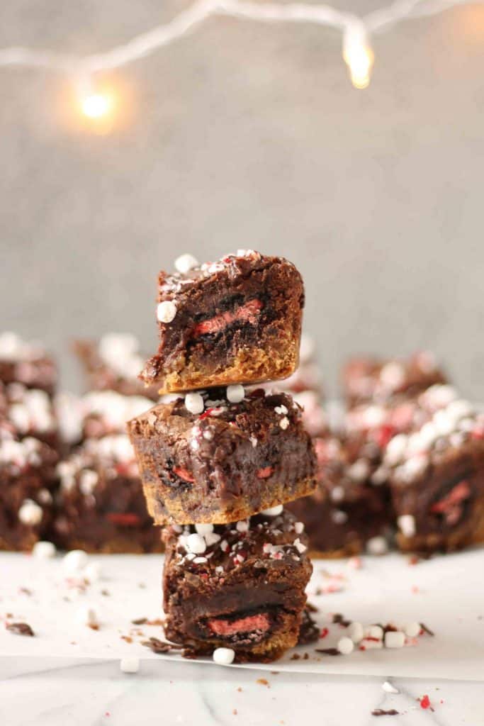 These Peppermint Hot Chocolate Brookies feature a layer of chocolate chip cookies, peppermint sandwich cookies, a layer of brownies and then topped with dark chocolate, crushed peppermint and mini marshmallows. | Strawberry Blondie Kitchen