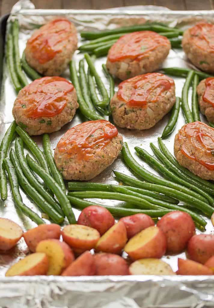 Sheet Pan Mini Meatloaves with Potatoes and Green Beans on a sheet pan before cooking in the oven