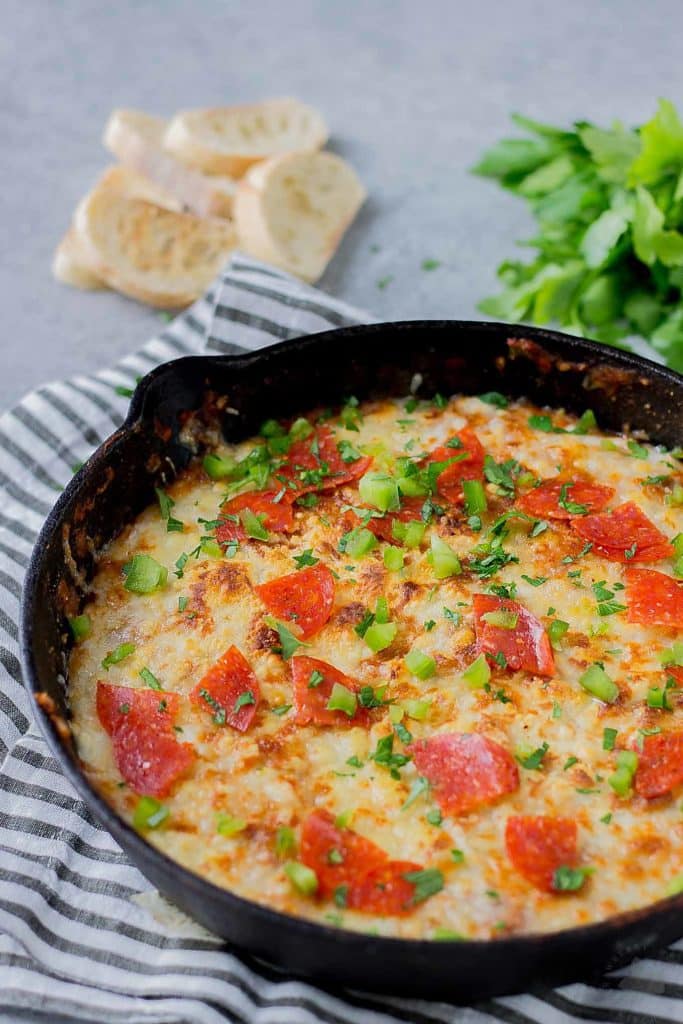 Supreme Pizza Dip is an ooey, gooey, cheesy dip sure to please everyone!  Filled with your favorite pizza toppings, it's sure to be a crowd pleaser! | Strawberry Blondie Kitchen