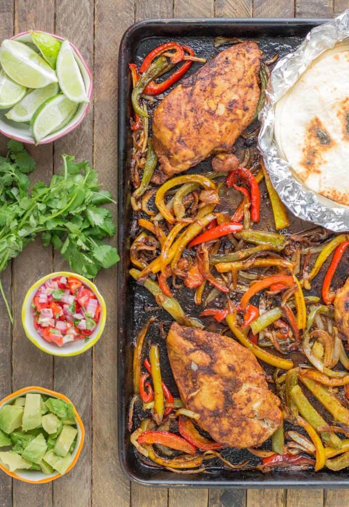 Bursting with flavor and cooked all on ONE pan, these easy Sheet Pan Chicken Fajitas are sure to become permanent in your dinner rotation. You'll love the quick cleanup too! | Strawberry Blondie Kitchen